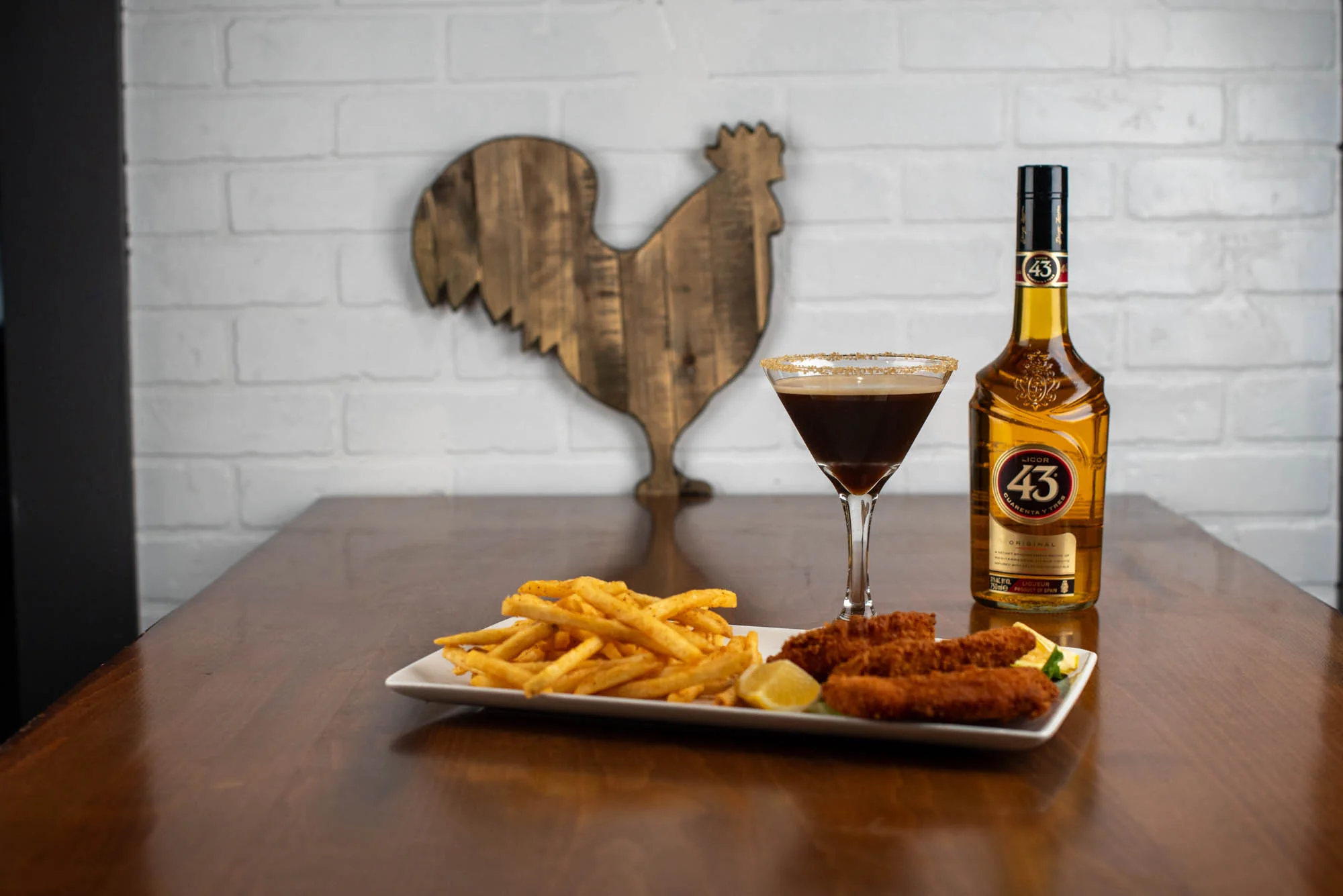 Rewsters wings and fries beside an espresso martini and a wooden rooster